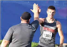  ?? PHOTOS BY RICK PECK/SPECIAL TO MCDONALD COUNTY PRESS ?? Peyton Barton gets a high five with coach Chris Kane after his final throw of 153-0 feet in the discus at the state track meet held May 25 at Jefferson City High School.