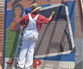  ?? ADRIAN MARSH/THE REPUBLIC ?? David Murietta works on a mural near Seventh Street and Portland Avenue in Phoenix that highlights the history of the Latino community in Arizona.