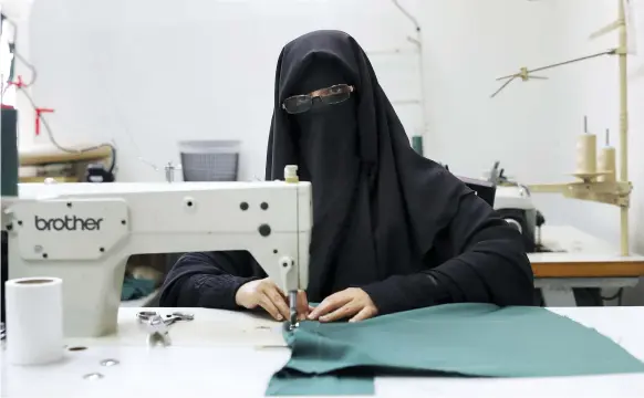  ?? Pawan Singh / The National ?? Aisha Saeed at work in the tailoring section of Dubai Police headquarte­rs. The seamstress aims to move into the field of computer sciences