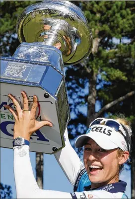  ?? JOHN BAZEMORE/AP 2021 ?? Nelly Korda of the U.S. hoists the trophy after winning the KPMG Women’s PGA Championsh­ip on June 27 at Atlanta Athletic Club in Johns Creek. Korda won her first major and an Olympic gold medal this year.