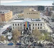  ?? Brittany Peterson Associated Press ?? A RAINBOW FLAG is unfurled at City Hall in Colorado Springs, where evangelism has shaped politics.