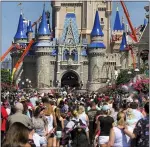  ?? JOE BURBANK — THE ASSOCIATED PRESS ?? A crowd is shown along Main Street USA in front of Cinderella Castle in the Magic Kingdom at Walt Disney World on March 12 in Lake Buena Vista, Fla.