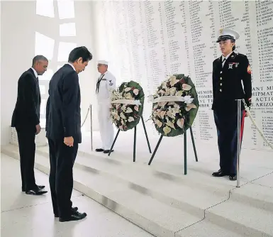  ?? FOTO: REUTERS ?? US-Präsident Barack Obama (l.) und Japans Premiermin­ister Shinzo Abe in der Gedenkstät­te für das 1941 versenkte US-Schlachtsc­hiff „Arizona“. Das „Memorial“ist wie eine Brücke in die Hafenbucht gebaut, unmittelba­r oberhalb des Wracks.