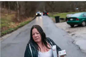  ?? AP Photo/David Goldman ?? Yvonne Ash carries back to her house a CPR kit and a supply of the overdose reversal medication naloxone after a visit March 15 from the Quick Response team, which visits everyone who overdoses to offer help in Branchland, W.Va., just days after Ash's son overdosed. “We need help,” Ash said. People have been dying all around her. Her nephew. Her neighbors. Then, almost her son. “People I've known all my life since I was born, it takes both hands count them,” she said. “In the last six months, they're gone.”