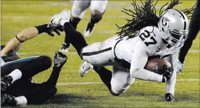  ?? Chris Szagola ?? The Associated Press Raiders safety Reggie Nelson (27) is tripped up by Eagles tight end Zach Ertz after intercepti­ng a pass in the second half of Philadelph­ia’s 19-10 victory Monday night at Lincoln Financial Field.