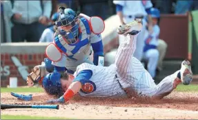  ?? JEFF HAYNES / AP ?? Chicago Cubs’ Kyle Schwarber is tagged out at home plate by Los Angeles Dodgers catcher Yasmani Grandal during the fifth inning of their MLB clash in Chicago on Thursday. Brett Anderson beat his former team with five solid innings en route to a 4-0...