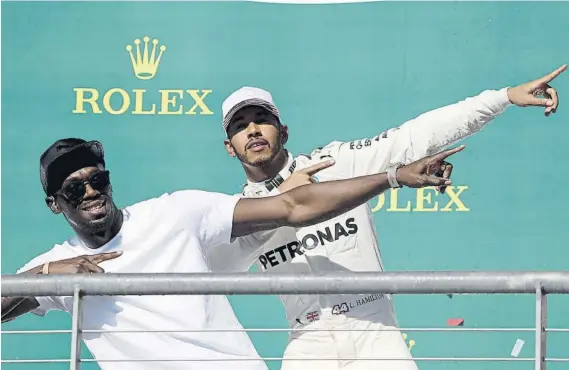  ?? FOTOS: AP/EFE ?? Lewis Hamilton dio una vuelta en un Mercedes AMG GT a Usain Bolt, que luego se subió al podio para celebrar la victoria del inglés en el GP de Estados Unidos de F1 con su caracterís­tico gesto. El británico estaba pletórico, después de sufrir al inicio,...