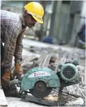  ??  ?? COLOMBO: A Sri Lankan constructi­on laborer works on a new apartment building at a complex in Colombo. — AFP