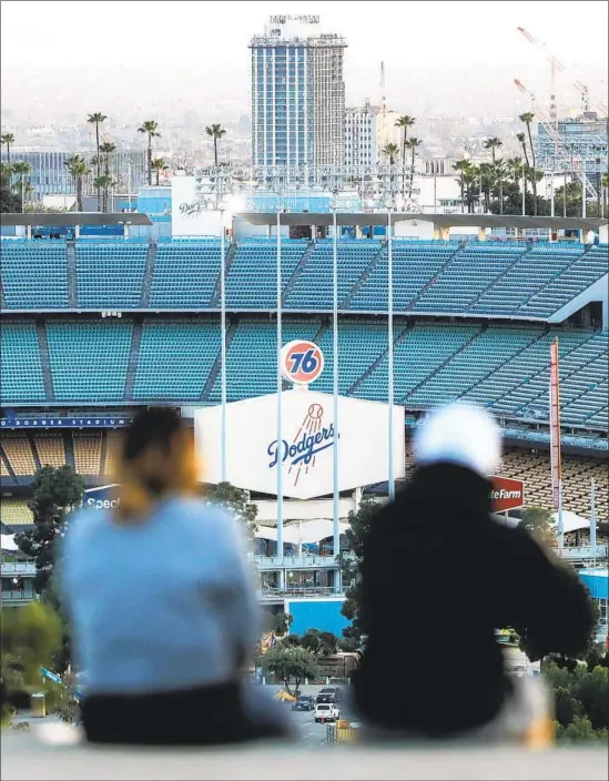  ?? Mario Tama Getty Images ?? SURE, THE STADIUMS will be empty (including Dodger Stadium here) when baseball starts, but that’s no reason fans shouldn’t feel like they’re close to the action.
