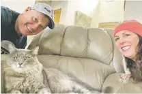  ?? COURTESY PHOTO ?? Jerome Coffidis, left, and Sharon Redsun show off Grayson, a cat they adopted, lounging in his favorite chair.