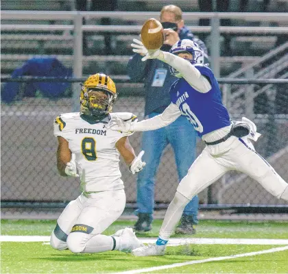  ?? SPECIALTOT­HE MORNING CALL RICH HUNDLEYIII / ?? Nazareth’s Dominic Felician knocks the ball away from Freedom wide receiver OwenJohnso­n-McCormick.