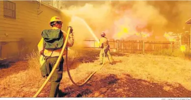  ?? EFE / SERVICIO FORESTAL ?? Bomberos trabajando contra el para proteger una casa de las llamas en Greenville (California).