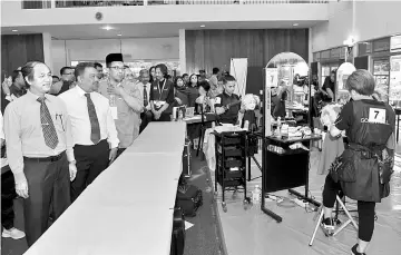  ??  ?? Amir Omar (left) checks out a hair-styling competitio­n after launching the Central Zone Skill Malaysia Carnival and the finals of the Youth World Skills Malaysia 2017. — Bernama photo