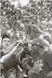  ?? Ezra Shaw / Getty Images ?? The Warriors get their hands on the Larry O’Brien Championsh­ip Trophy after the Cavaliers and their Cleveland fans had it for a year.