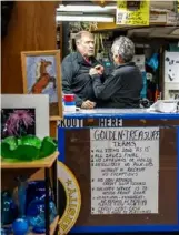  ?? ?? John Golden gets some help adjusting his collar from his wife, Anna Golden, in their Braddock store, Golden Treasures.