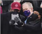  ?? The Associated Press ?? Rep. James Clyburn of South Carolina, and former president George W. Bush, take a selfie before Joe Biden’s inaugurati­on.