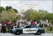  ?? TERRY RENNA — THE ASSOCIATED PRESS ?? In this file photo, a police car drives near Marjory Stoneman Douglas High School in Parkland, Fla., as students return to class for the first time since a former student opened fire there with an assault weapon. Calls to encourage school districts to...