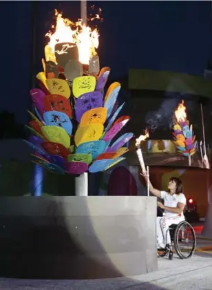  ?? BERNARD WEIL/TORONTO STAR ?? Legendary Canadian wheelchair racer Chantal Petitclerc, who has won 14 Paralympic gold medals, lights the cauldron Friday night at York University during the opening ceremony.