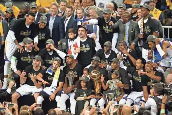  ?? CARY EDMONDSON, USA TODAY SPORTS ?? Warriors players and staff pose with the Larry O’Brien Trophy after winning the title Monday.