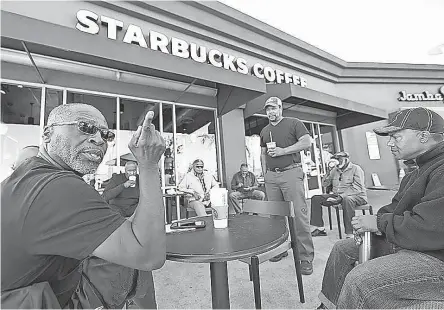  ??  ?? Fred Jackson, left, and Troy Huey chat at the Ladera Heights Starbucks, which has become a community gathering spot.