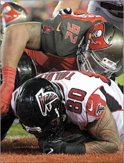  ?? AP/PHELAN M. EBENHACK ?? Levine Toilolo (80) recovers a fumble by teammate Devonta Freeman in the end zone for a touchdown as the Buccaneers’ William Gholston defends Monday in Tampa, Fla. Atlanta took a 14-7 lead on the play in the second quarter en route to a 24-21 victory.