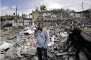  ?? AP ?? Ratib Matar, a Palestinia­n whose family home was demolished by Israeli authoritie­s, talks on his mobile phone in the rubble of the home that sheltered 11 people, in the Jabal Mukaber neighborho­od of east Jerusalem.