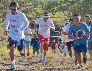  ??  ?? Manny Pacquiao wears the shirt on which is printed ‘FIGHT ON’ as he is joined in the trail run by his supporters during training.