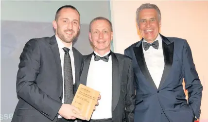  ?? Pictures: Roger Donovan ?? > Paul Rowland, of WalesOnlin­e, collects the News Website of the Year award from Spencer David, centre, with Dermot Murnaghan of Sky News, right