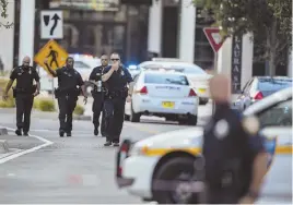  ?? AP PHOTOS ?? ‘POP, POP, POP’: Police gather after an active shooter, above, was reported at an online video game tournament. Police, below, investigat­e the scene at The Jacksonvil­le Landing on Aug. 26.