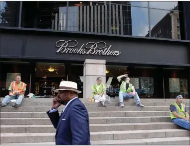  ?? (AP/Mark Lennihan) ?? A man passes a Brooks Brothers store in New York in this file photo. The Manhattan fashion retailer is filing for bankruptcy protection.