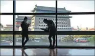  ?? ZOU HONG / CHINA DAILY ?? People read books in PageOne bookstore in Qianmen that boasts panoramic views of ancient architectu­re.