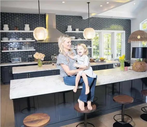  ?? Jay L. Clendenin Los Angeles Times ?? “IT’S WHERE EVERYONE loves to be,” Molly Sims — here with daughter Scarlett — says of the kitchen she describes as cozy.