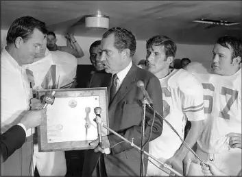  ?? The Associated Press file ?? President Richard Nixon presents a plaque to Texas football coach Darrell Royal after the Longhorns defeated Arkansas on Dec. 6, 1969, in Fayettevil­le, Ark.