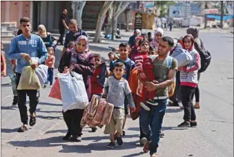  ?? Right: ?? Palestinia­ns ride on a donkey-drawn cart as they flee their homes during Israeli air and artillery strikes, in the northern Gaza Strip, yesterday. artillery strikes, to a safer location.
Palestinia­ns carry some of their belongings in Beit Hanun in the northern Gaza Strip, as they flee air and