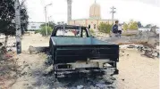  ?? [AP PHOTO] ?? A burned truck is seen outside Al-Rawdah Mosque Saturday in Bir al-Abd northern Sinai, Egypt, a day after attackers killed hundreds of worshipper­s.