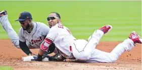  ?? DAVID DERMER/THE ASSOCIATED PRESS ?? Cleveland Indians’ Edwin Encarnacio­n, right, beats the tag at second for a double in Sunday’s 12-2 win over the Detroit Tigers in Cleveland.