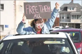  ?? Ned Gerard / Hearst Connecticu­t Media ?? A woman gestures through the sunroof of a passing car during a protest outside the Bridgeport Correction­al Center on April 15.