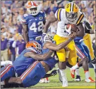  ?? AP/ The Advocate/ BILL FEIG ?? LSU running back Leonard Fournette, trying to escape two Florida tacklers, has been a major force for No. 2 LSU, rushing for 1,034 yards and scoring 10 touchdowns.