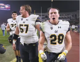  ?? Harry How / Getty Images ?? Running back Patrick Laird (28) and center Addison Ooms (57) celebrate after Cal beat USC for the first time since 2003 — and first time in L.A. since 2000.