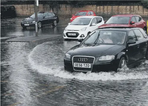  ??  ?? Motorists struggled through flooded roads.