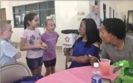  ?? BRIANA CONTRERAS — THE MORNING JOURNAL ?? Students of Oakwood Elementary in Elyria, from left, Eli Marcum, 7, Ameerah Taylor, 9, and Olivia Marcum, 9, excitedly greet their principal Joy Jones and Assistant Prinicpal of Elyria High School, Jodie Johnson, far right, at Elyria City Schools’...