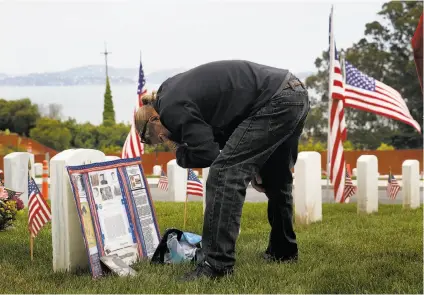  ?? Photos by Liz Hafalia / The Chronicle ?? Above: At the Presidio cemetery, Kevin Claire pays a Memorial Day visit to the tombstone of his brother Kenneth Claire, who served in the Vietnam War. Below: Veterans Bob Hansen (center left) and Chuck Paskerian (center right) salute.