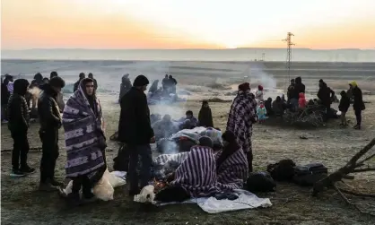  ?? Photograph: Osman Örsal/Getty Images ?? Refugees and migrants rest near Pazarkule border as they attempt to enter Greece from Turkey.