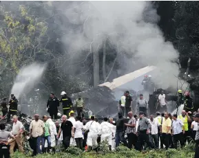  ?? ENRIQUE DE LA OSA / THE ASSOCIATED PRESS ?? Cuba’s President Miguel Diaz-Canel, third from left, walks away from the site where a Boeing 737 plummeted into a field with more than 100 passengers on board, in Havana, Cuba, on Friday. It crashed shortly after takeoff.