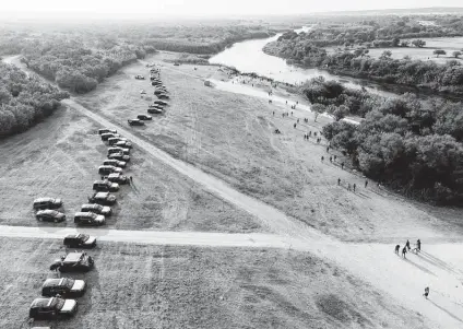  ?? Associated Press file photo ?? Official vehicles line up close to a camp of migrants, many from Haiti, near the Del Rio Internatio­nal Bridge in September. Del Rio is in Val Verde County, where, in recent months, state authoritie­s have stopped arresting migrants, according to one official.