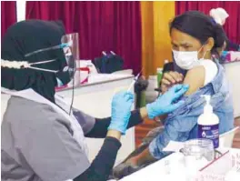  ??  ?? EASY DOES IT ... A foreign worker getting a jab as part of the Selvax community Covid-19 vaccinatio­n programme at the PKNS Sports Complex in Kelana Jaya, Petaling Jaya yesterday. – ASYRAF RASID/THESUN