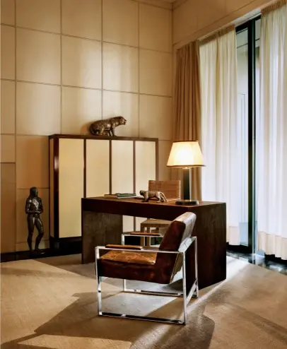  ??  ?? DANS LE BUREAU, devant le cabinet en parchemin, un secrétaire de Jean- Michel Frank et un fauteuil de Le Corbusier. La lampe des années 1930 a été chinée.