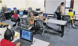  ?? BY JIMMY SWINDLER ?? RCES reading interventi­on teacher Katherine Todd (kneeling) and RCPS Director of Instructio­n Shannon Grimsley (standing) work with students using Imagine Learning Instructio­nal Software.