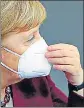  ?? REUTERS ?? German Chancellor Angela Merkel adjusts her mask after delivering a speech.