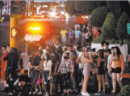  ?? Ellen Schmidt Las Vegas Review-journal @ellenkschm­idttt ?? Visitors wait to cross the street Saturday outside Caesars Palace on the Strip.